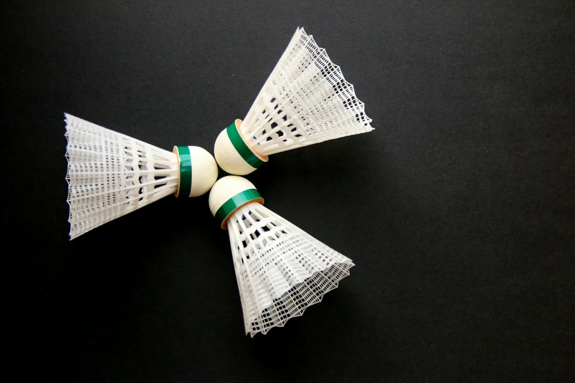 A close up of two white and green bows on a black surface